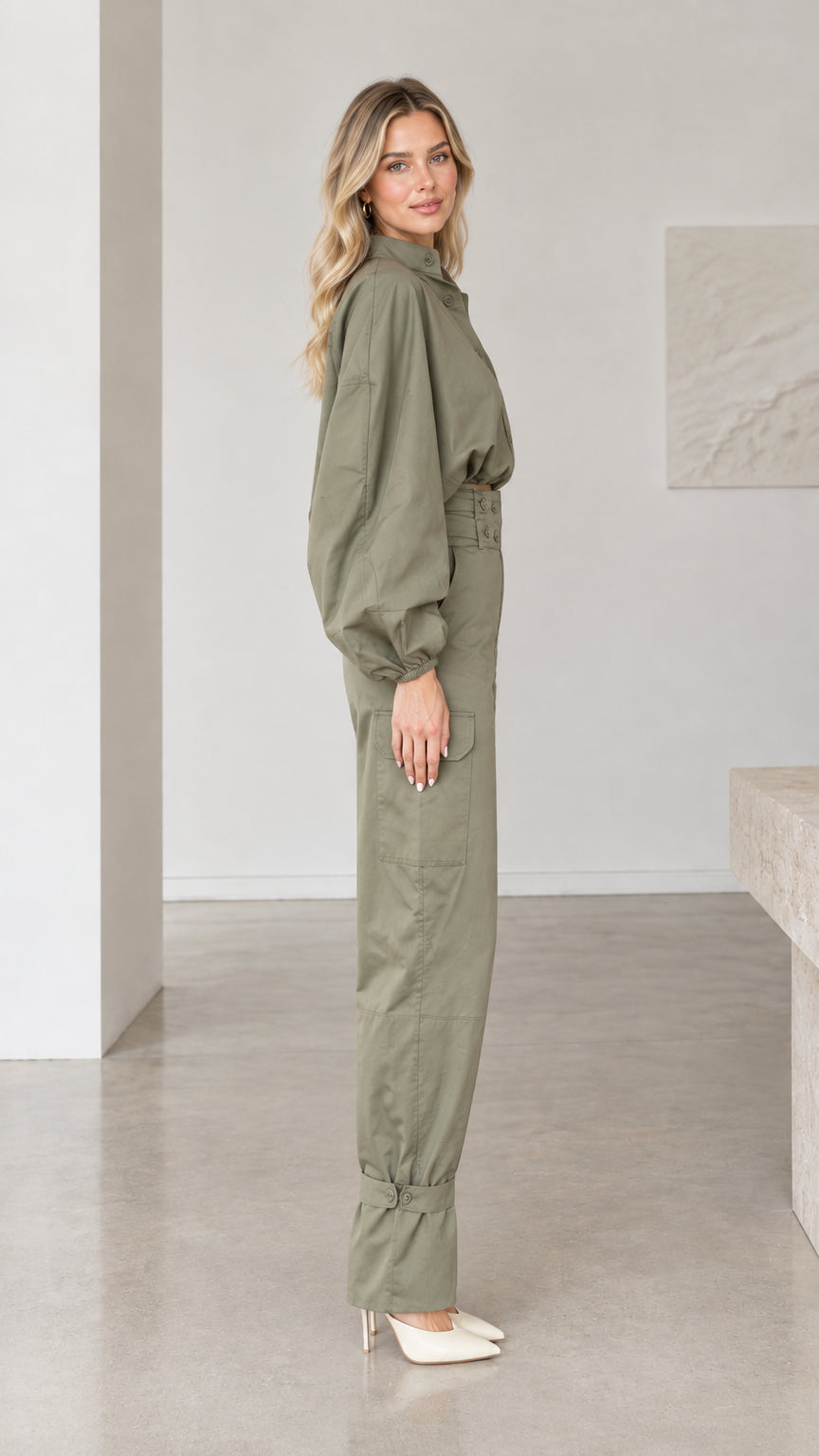 Side profile view of woman modeling olive green long sleeve utility jumpsuit