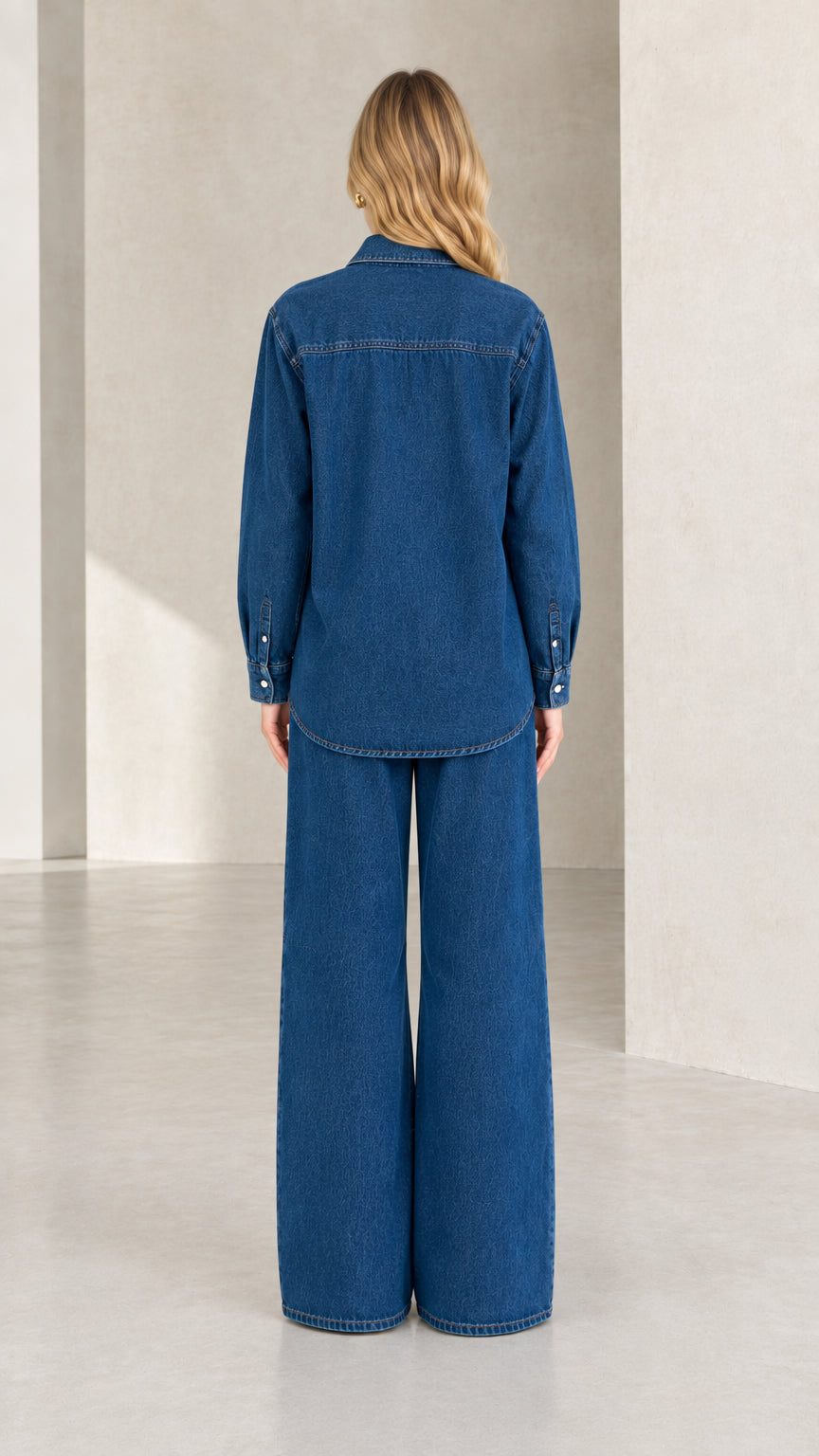 Back view of model in classic blue denim shirt and wide-leg trousers