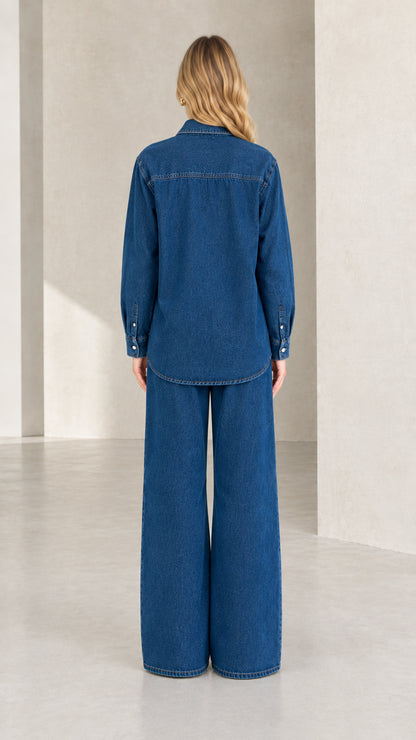 Back view of model in classic blue denim shirt and wide-leg trousers