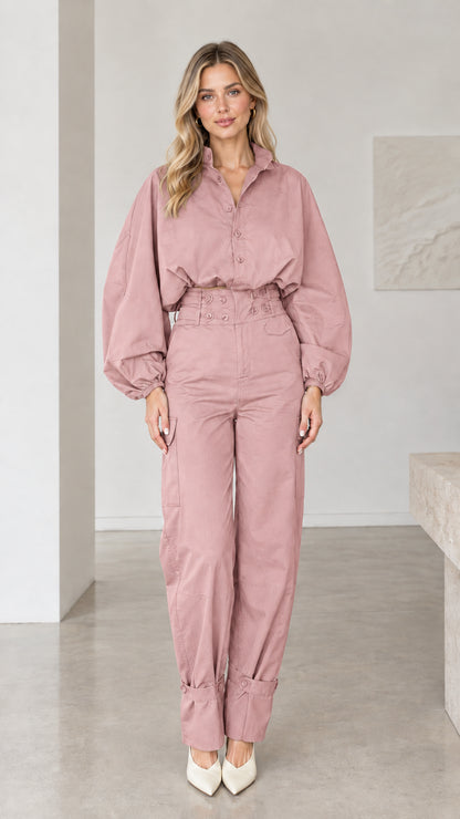 Front view of woman wearing dusty pink balloon sleeve button-up jumpsuit