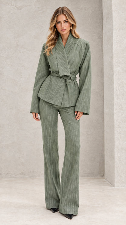 Front view of model wearing sage green pinstripe wrap blazer and flare pants