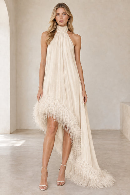Model wearing champagne ivory halter high-low evening gown with feather trim